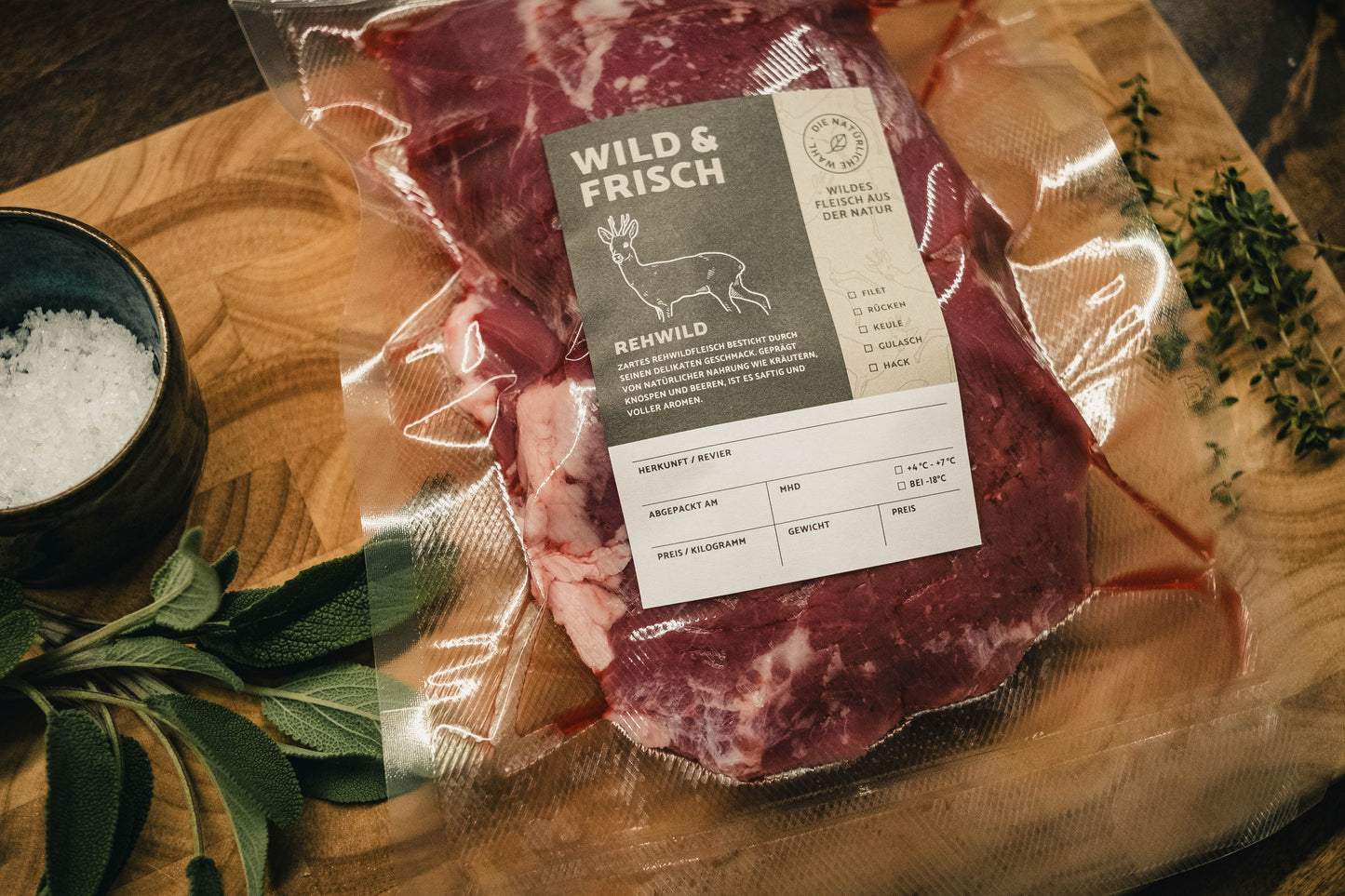Aufkleber Wild & Frisch auf eingeschweißtem Fleisch auf Holzbrett